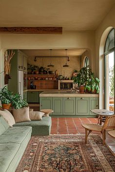 a living room filled with furniture next to a kitchen and dining area on top of a rug