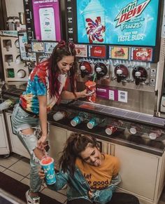 two young women are sitting at a coffee shop and one is holding a soda in her hand