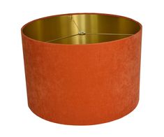 an orange lamp shade hanging from a ceiling fixture with a gold rim and metal ring