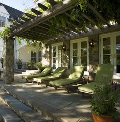 an outdoor patio with chaise lounges and potted plants