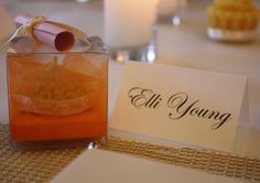 there is a small glass container with food in it next to a card that says eli young