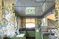 the inside of a camper with curtains and bedding on it's sides