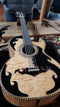 an acoustic guitar sitting on top of a wooden table