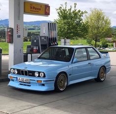 a blue car parked at a gas station