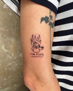 a woman with a tattoo on her arm that reads i'm fine and has a dog