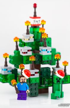 a lego christmas tree made out of green and red bricks with a person holding a toy