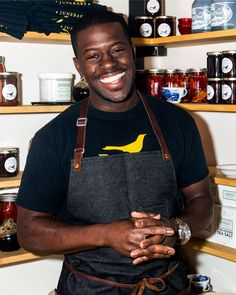 a man wearing an apron and smiling for the camera