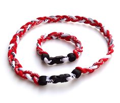 a red, white and black rope with two black beads is shown on a white background