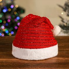 a red and white santa hat sitting on top of a wooden table