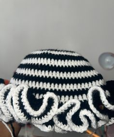 a black and white crocheted hat sitting on top of a table