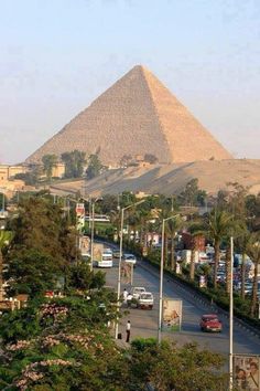 the great pyramid in giza, egypt with cars parked on the street below it