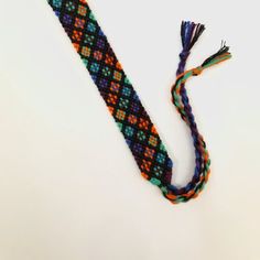 a multicolored tie with tassels is laying on the floor next to it