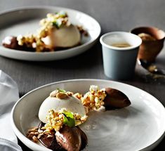 two white plates topped with desserts on top of a table