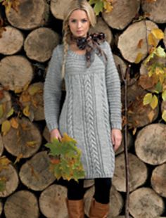 a woman standing in front of a pile of logs