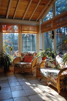 the sun shines through two large windows into a living room with wicker furniture and potted plants