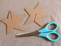 some cut out stars sitting next to a pair of scissors