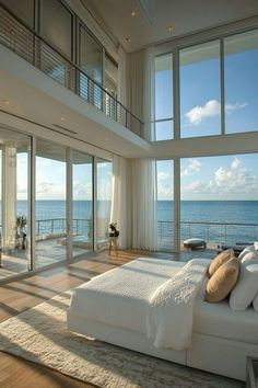 a bedroom with large windows overlooking the ocean