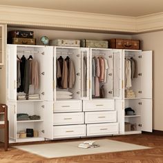 a large white closet with drawers and clothes hanging on the wall next to a desk