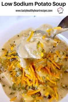 a white bowl filled with soup and cheese covered in gravy next to a spoon