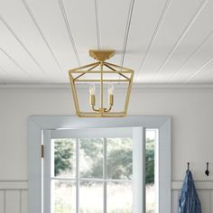 a light fixture hanging from the ceiling above a bed in a room with white walls