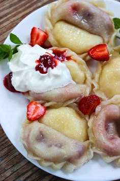 some dumplings with strawberries and cream on a white plate