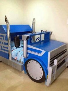 a bed made to look like a tractor with wheels on the bottom and sides, sitting in a room