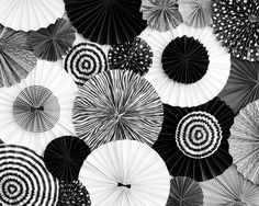 many black and white umbrellas are arranged in the shape of an abstract spiral pattern