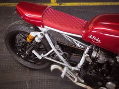 a red motorcycle parked on top of a parking lot