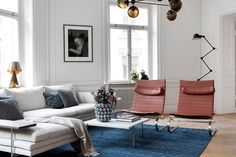 a living room with two couches, chairs and a coffee table in front of a window