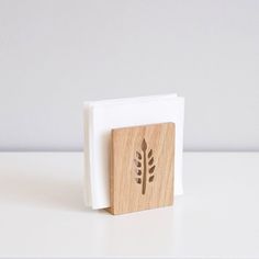 a wooden block with a leaf carved on it's side sitting on a white surface