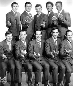 a group of men in suits and ties posing for a photo with their hands together