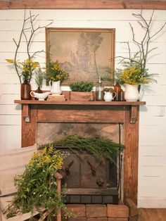 an old fireplace with potted plants on it and a painting above the fire place