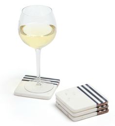 a glass of white wine sitting on top of coasters