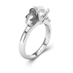 a white gold engagement ring with a single stone in the center and a small diamond on the side