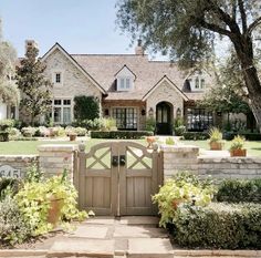 a large house with a gate in front of it and lots of greenery around the entrance