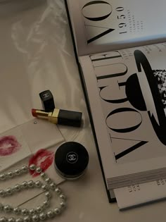 the contents of a chandelier, lipstick, and pearls are laid out on a table