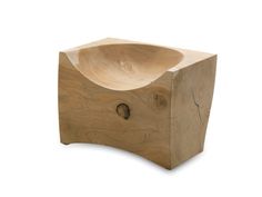 a wooden bowl sitting on top of a piece of wood with holes in the middle