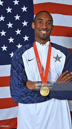 an olympic athlete poses for a photo with his gold medal in front of the american flag