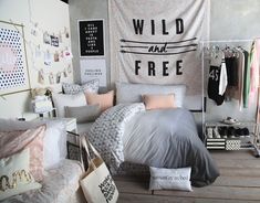 a bed room with a neatly made bed next to a large wall hanging on the wall