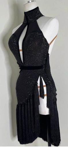 a mannequin wearing a black dress with fringes on it's neck