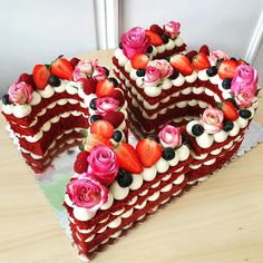 a heart shaped cake with flowers and berries on top