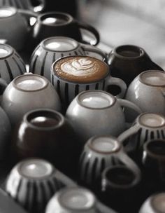 there are many black and white vases with designs on the top one is filled with coffee