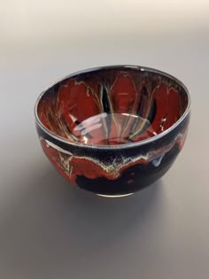 a red and black bowl sitting on top of a table