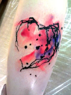 a watercolor tattoo on the leg of a woman's arm with an abstract heart