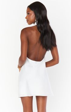 Our best selling halter maxi is now in mini length! This white mini is cut on the bias to give that perfect slip draping we're all looking for. The top softly wraps around your neck for a flattering high neck and leaves a dramatic open back. Beyond chic for a bridal shower and a new go-to for special occasions and events! White Spaghetti Strap Backless Dress For Date Night, White Backless Mini Dress For Date Night, Chic Halter Dress With Cowl Back For Evening, White Backless Dress For Date Night, White Satin Backless Slip Dress, Chic White Backless Dress For Night Out, Summer Evening Halter Dress With Keyhole Back, Chic Halter Dress With Spaghetti Straps And Back Opening, Sleek Summer Backless Dress With Tie Back