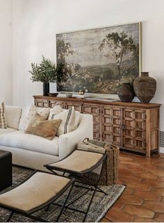 a living room filled with furniture and a painting on the wall