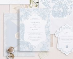 the wedding stationery is laid out on top of each other, including an envelope and ring