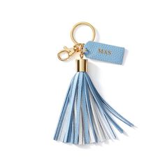 a blue and white tasselled keychain with a name tag on it