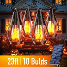 the solar powered lantern is lit up in front of a house with pumpkins and jack - o'- lanterns