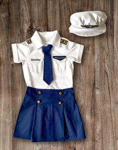 a uniform and hat are laid out on a wooden floor, including a sailor's outfit